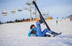 Young,girl,skier,in,blue,ski,suit,after,the,fall