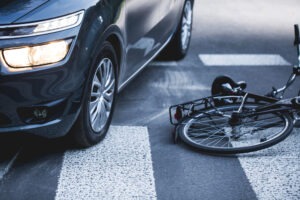 A car and bicycle in the road after an accident. 