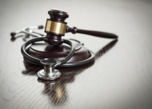 Gavel,and,stethoscope,on,reflective,wooden,table