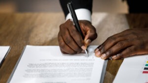 Man signing paperwork with pen