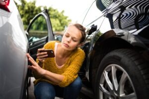 woman taking picture of crash damage